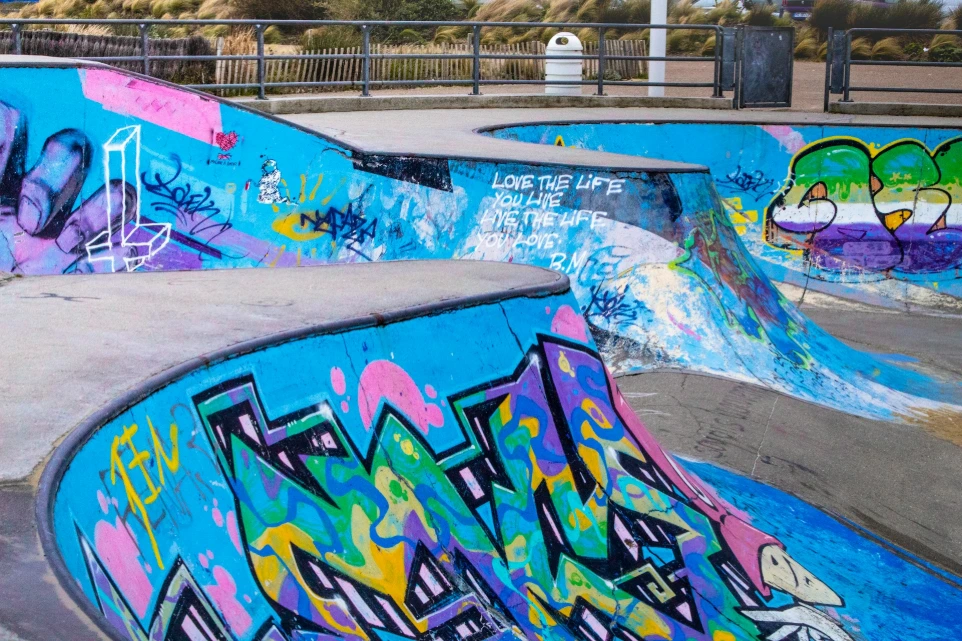 a group of skateboard ramps covered in graffiti